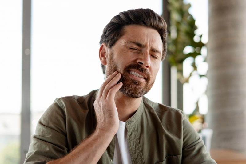 man dealing with oral pain 