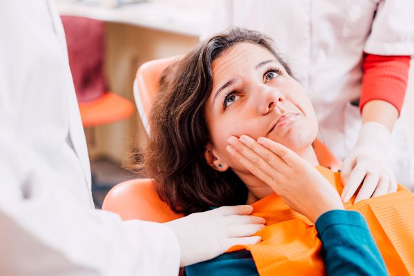 A woman with a toothache in a dentist’s chair.