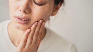 Woman grimacing due to a toothache 