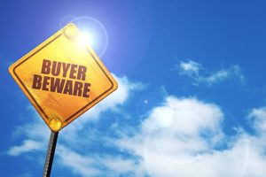 Yellow sign that says, “Buyer Beware”